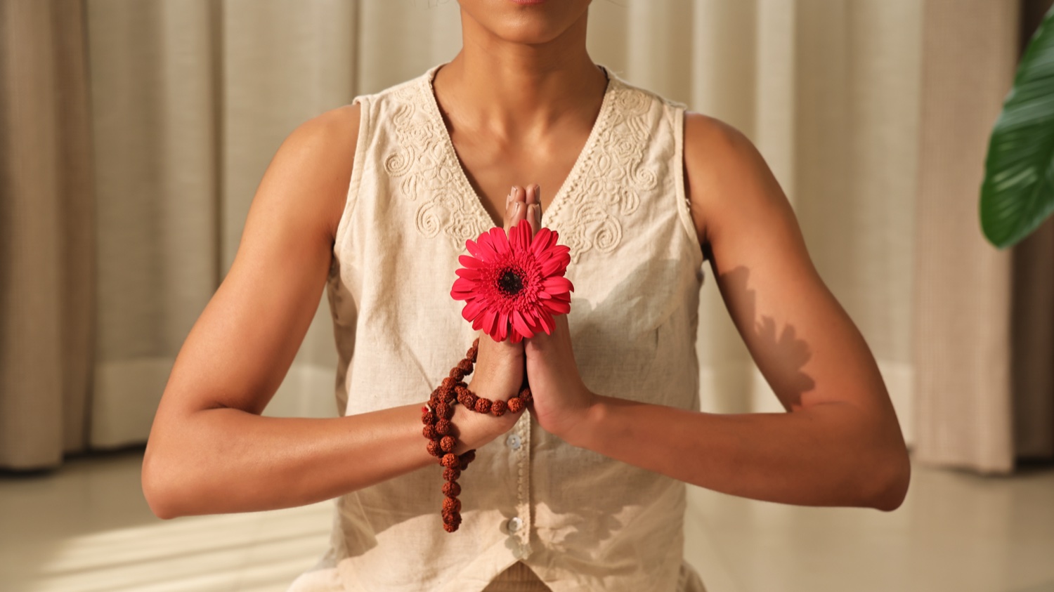 Frau mit Blume in einer Namaskar-Geste für Art of Vedas